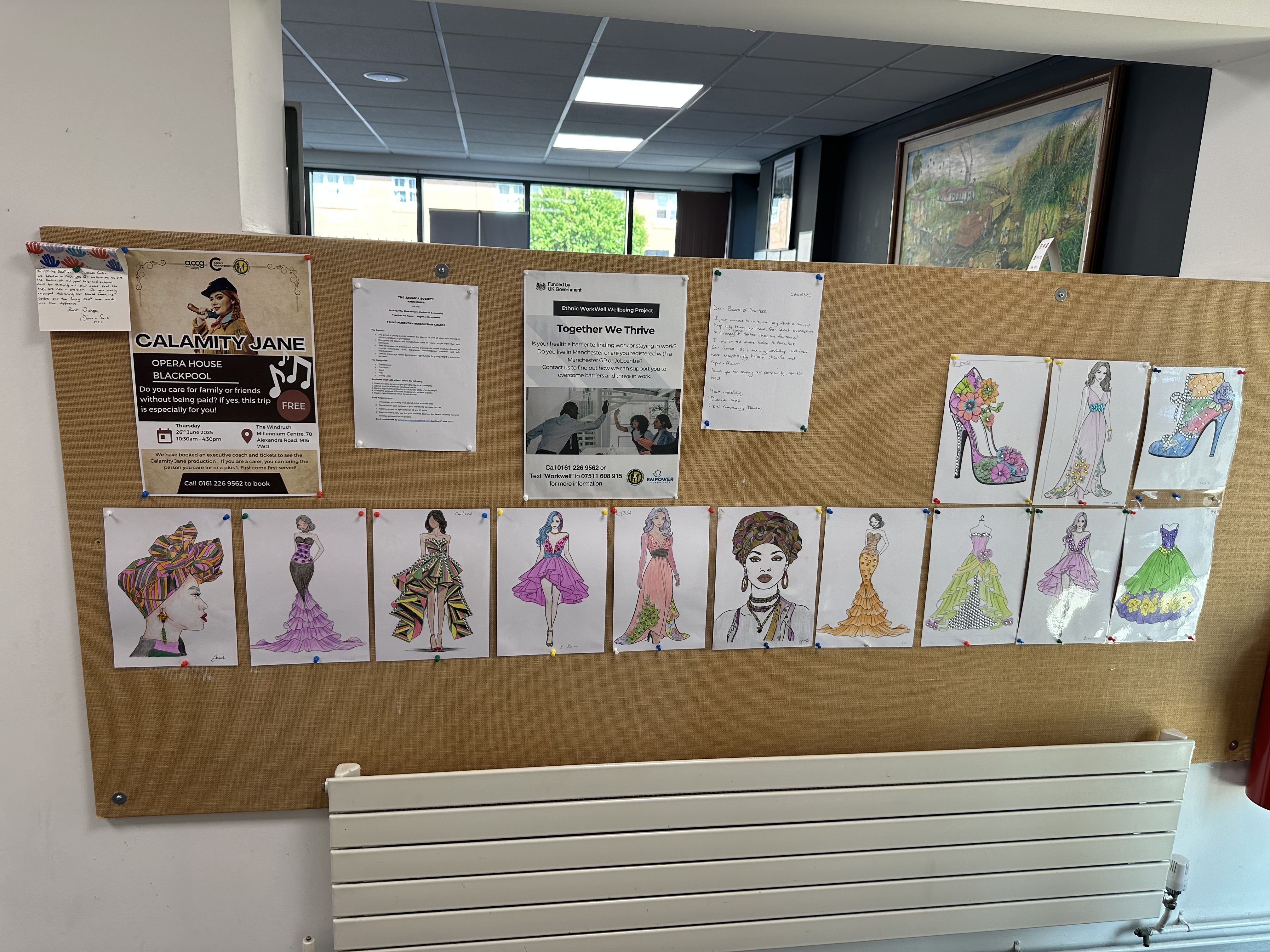 Display board showing various colorful artworks from group members