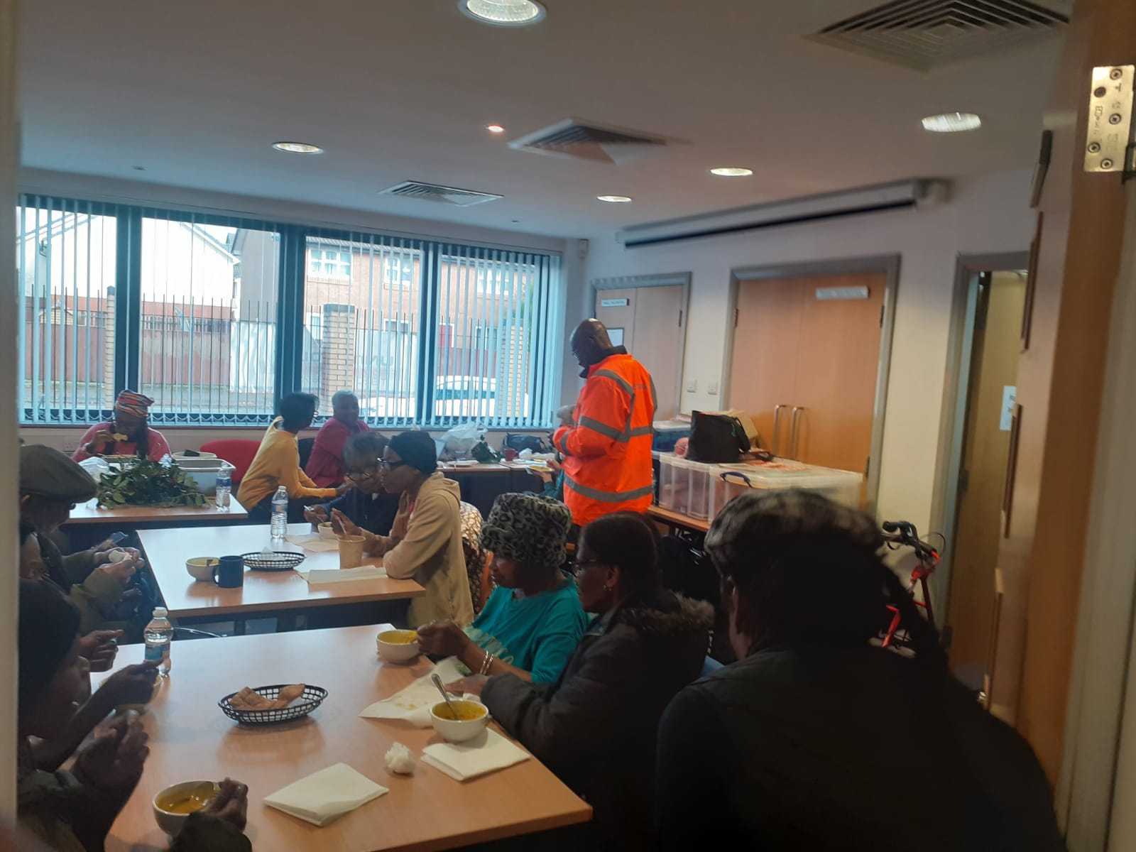 Volunteers serving community members in dining room