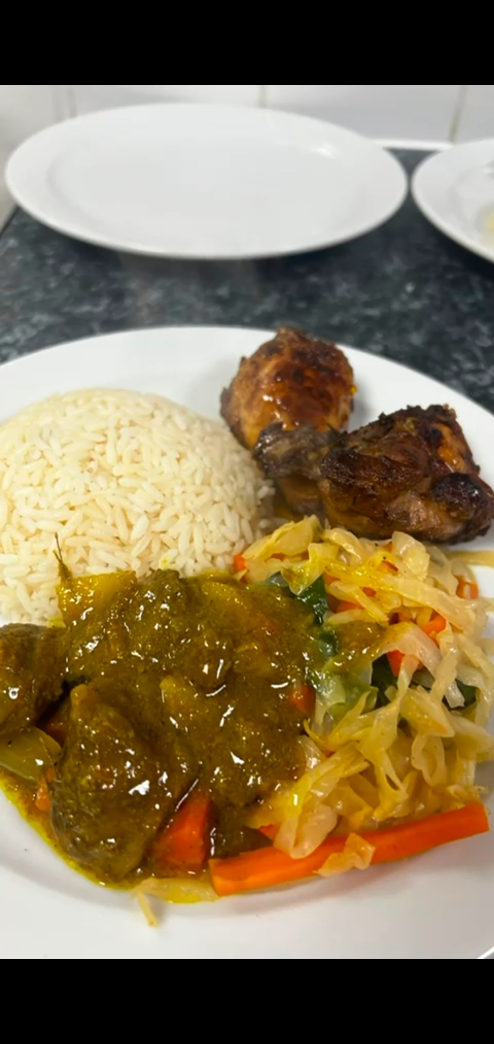 Caribbean meal with jerk chicken, rice, curry, and coleslaw