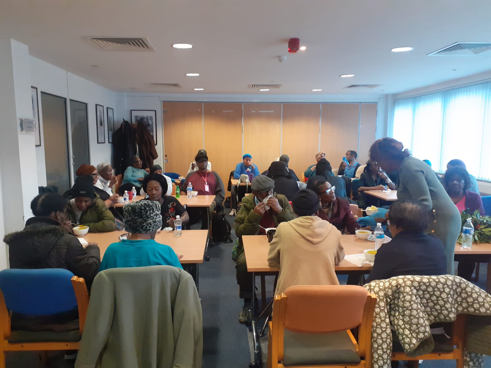 Dining room with community members sharing a meal