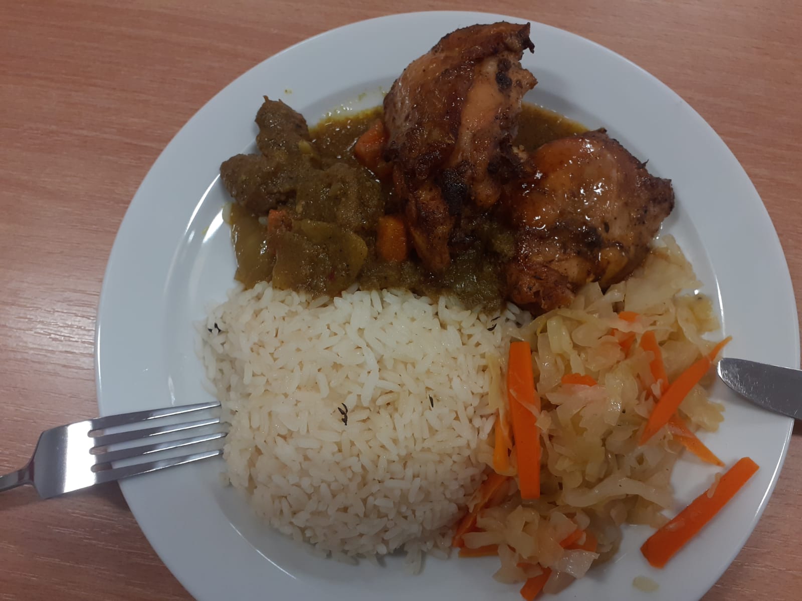 Homemade meal with rice, chicken, curry, and coleslaw
